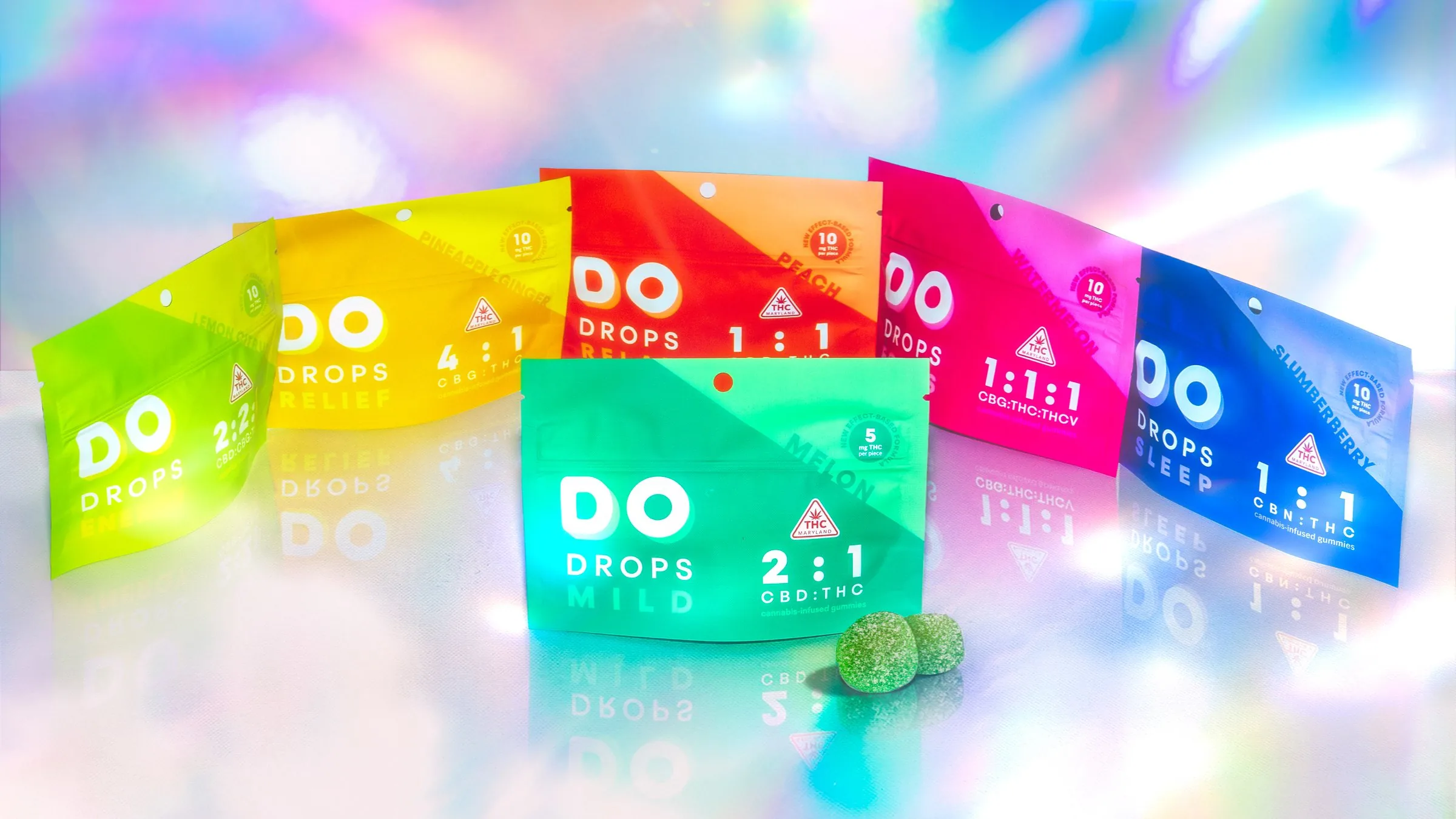 The full DO Drops lineup fanned out across a holographic surface, one pouch for every effect in the range.